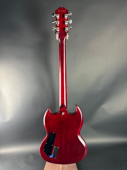 Red electric guitar on a reflective gray surface