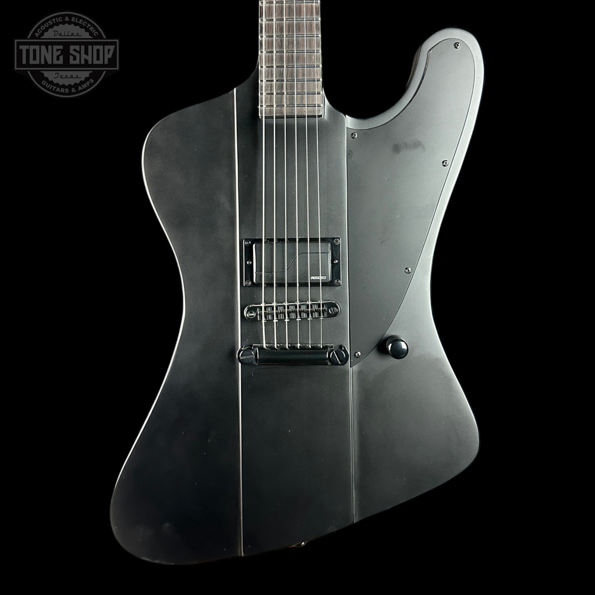 Black electric guitar on a black background with 'Tone Shop' logo.