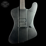 Black electric guitar on a black background with 'Tone Shop' logo.