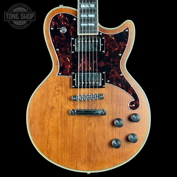 Electric guitar with a tortoiseshell pickguard on a black background, featuring the Tone Shop logo.