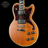 Electric guitar with a sunburst finish on a black background, featuring the Tone Shop logo.