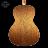 The back of an acoustic guitar with a warm brown wood finish, shown against a solid black background with a Tone Shop watermark in the top left corner.