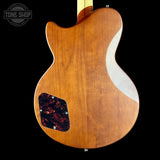 Back view of a wooden guitar with a visible brand logo in the corner.