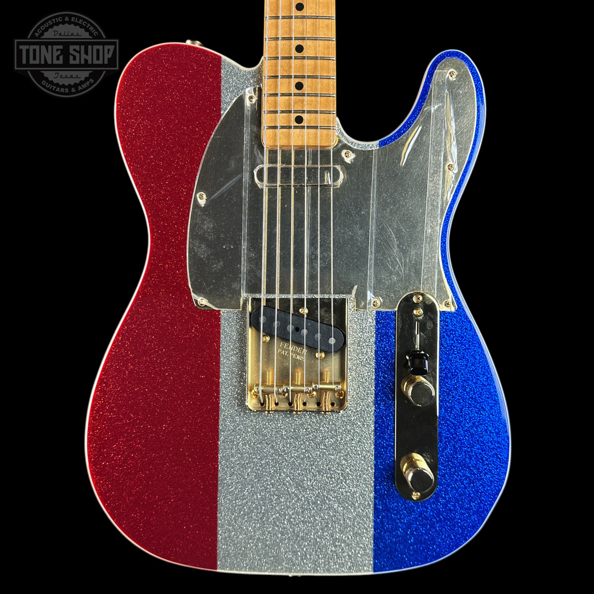 A custom glitter-finish electric guitar with vertical red, silver, and blue stripes on the body, a maple neck, and a clear protective cover over the pickups and control plate, shown against a black background.