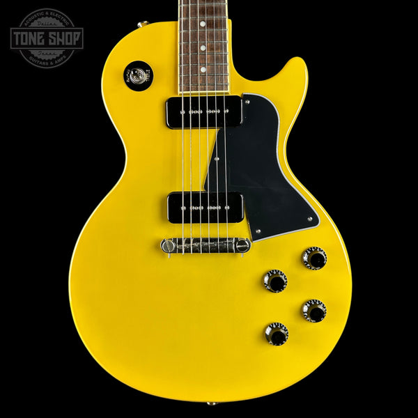Yellow electric guitar with a black pickguard on a black background, featuring the Tone Shop logo.