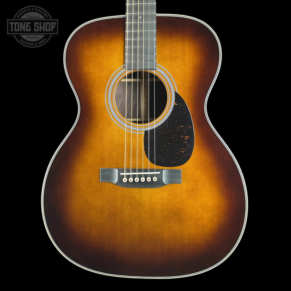 A classic acoustic guitar with a natural sunburst finish, shown from the front against a solid black background. The brand logo 'TONE SHOP' is visible as an overlay in the top-left corner.