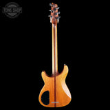 The back view of a modern electric bass guitar with a glossy natural wood finish, shown against a solid black background. The brand name 'Bodhrán' is visible near the bottom edge of the body, and a 'Tone Shop' watermark is in the top-left corner.