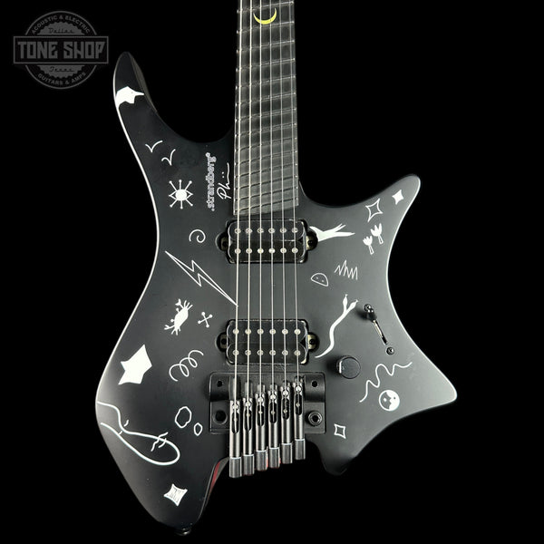 Black electric guitar with white designs on a black background, featuring the 'Tone Shop' logo.