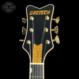 Gretsch guitar headstock with gold tuning pegs on a black background