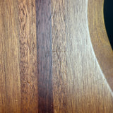 Close-up of a wooden surface showing a natural wood grain pattern with alternating light and dark brown stripes.