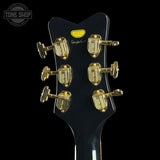 Close-up of a guitar headstock with tuning pegs on a black background, featuring the Tone Shop logo.