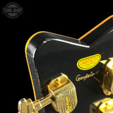 Close-up of a guitar's tuning pegs with Greisch branding on a black background.