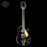 Electric guitar with gold hardware on a black background, featuring the Gretsch logo.