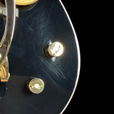 Close-up of a guitar's control knobs on a black background