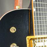Close-up of a guitar's neck and headstock with a focus on the tuning pegs.