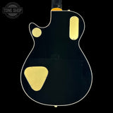 Black electric guitar with gold hardware on a black background, featuring 'Tone Shop' logo.