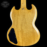 The back of a Gibson SG electric guitar in a natural wood finish, showing the maple wood grain and a black pickguard, set against a solid black background with a Tone Shop watermark in the top left.