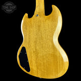 Close-up of the back body of an electric guitar with a natural flamed maple wood finish, showing the wood grain and a black pickguard against a black background.