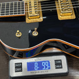 Black electric guitar on a digital scale displaying weight