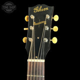 Gibson guitar headstock with gold tuning pegs on a black background