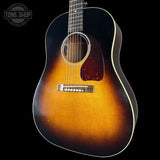 Acoustic guitar with a sunburst finish on a black background, featuring the Tone Shop logo.