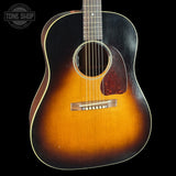 Acoustic guitar with a sunburst finish on a black background, featuring the Tone Shop logo.