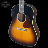 Acoustic guitar with a sunburst finish on a black background, featuring the Tone Shop logo.