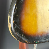 Close-up of a guitar's soundhole with a dark border and wooden center.
