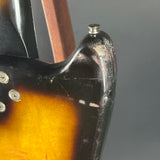 Close-up of a guitar's headstock and tuning pegs on a gray background