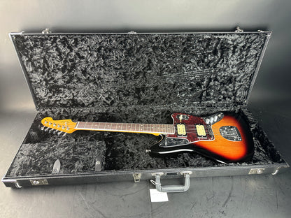 Electric guitar in a hard-shell case on a gray surface