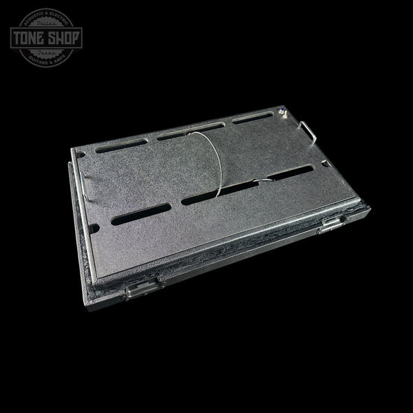 Black metal pedal board with cutouts on a black background, featuring 'Tone Shop' logo.