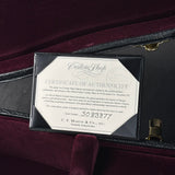 A framed Certificate of Authenticity for a Martin Custom Shop guitar, displayed inside an open black case lined with deep burgundy velvet. The certificate is mounted on a black plaque with a silver border.