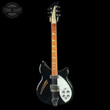 Electric guitar with a black and white design on a black background, featuring the 'Tone Shop' logo.