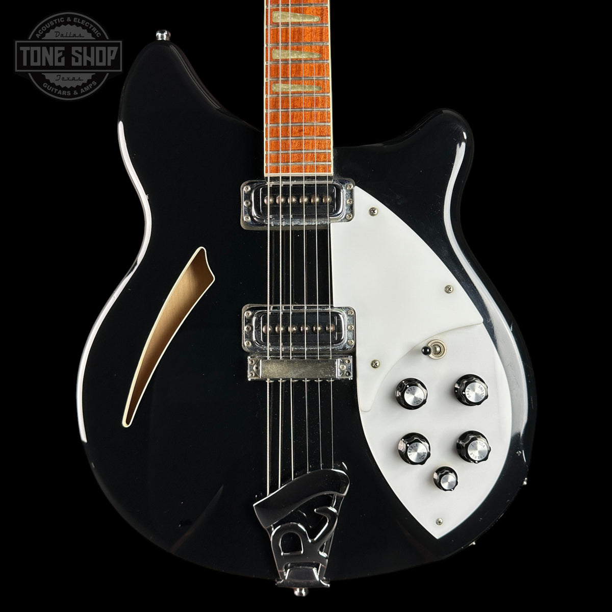 Black and white electric guitar with a visible brand logo in the corner.