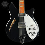 Black and white electric guitar with a visible brand logo in the corner.
