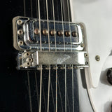 Close-up of a guitar's bridge and strings with a black and white background