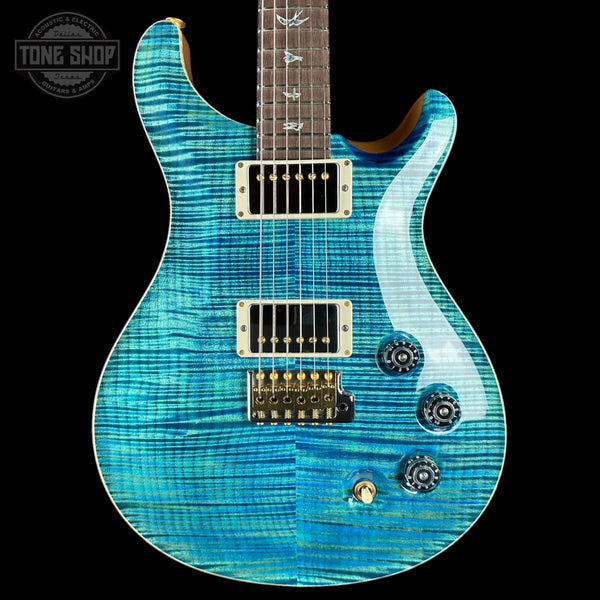 A blue flamed maple electric guitar with gold hardware and a dark fretboard, shown against a black background with a Tone Shop watermark in the top left corner.