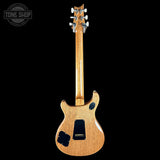 A natural wood electric guitar shown from the back against a solid black background, featuring a maple body, black pickguard, and a Tone Shop watermark in the upper left corner.