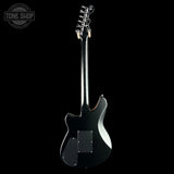 Black electric guitar on a white background with 'Tone Shop' logo.