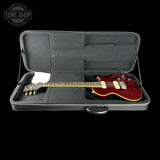Guitar in a hard case with 'Tone Shop' logo in the corner