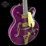 Purple electric guitar with gold hardware on a black background, featuring 'Tone Shop' logo.
