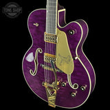 Purple electric guitar with gold hardware on a black background, featuring 'Tone Shop' logo.