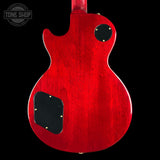 The back of a red electric guitar with a glossy cherry red finish, black pickguard, and gold hardware, shown against a solid black background with a Tone Shop watermark in the top left.