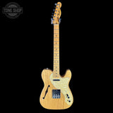 Electric guitar with a wooden body and pickguard on a black background, featuring 'Tone Shop' branding.