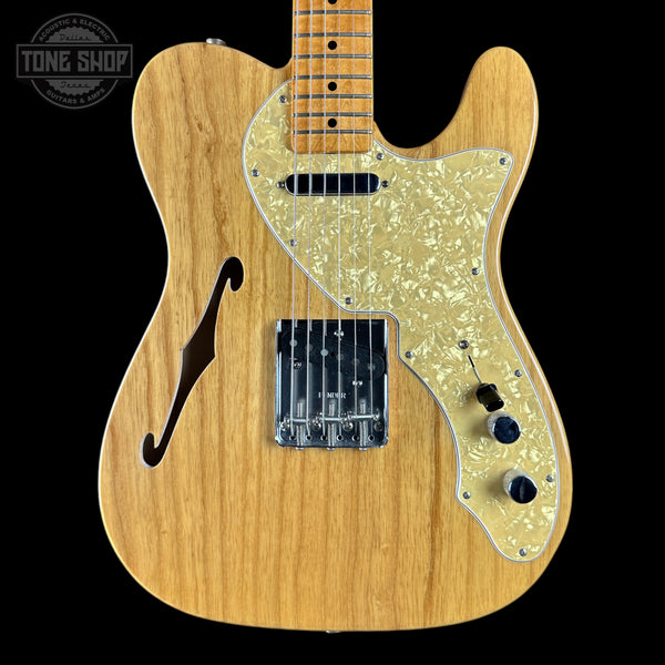 Wooden electric guitar with a visible brand logo in the corner