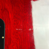 Close-up of a glossy red wood-grain surface with a vertical white section, a small black edge visible on the left, and a few small scratches on the red area.