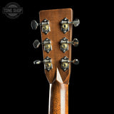 Close-up of a guitar headstock with tuning pegs on a black background, featuring the Tone Shop logo.