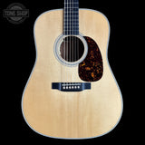 Acoustic guitar with a visible brand logo on a black background