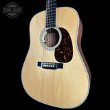 Acoustic guitar with a visible brand logo on a black background