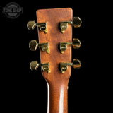 Close-up of a guitar headstock with tuning pegs on a black background, featuring the Tone Shop logo.